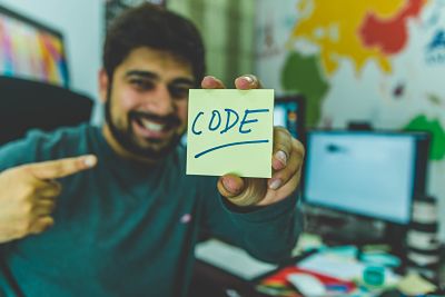 man pointing to CODE on a post-it