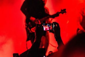 Photo of person recording a musician on their phone by Sergio Alejandro Ortiz on Unsplash